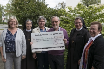 Das Osterkerzen-Team, (v.l.) Ursula Jung, Maria Schleyer, Klaus Harnischmacher und Dagmar Keuper, überreicht den Erlös von 1100 Euro der Provinzoberin Sr. M. Angela Benoit (2.v.l.) und Sr. M. Alexa Furmaniak (2.v.r.). Nicht im Bild zu sehen sind Nicole Fraune und Ramona Kissing.   Foto: Thorsten Harnischmacher